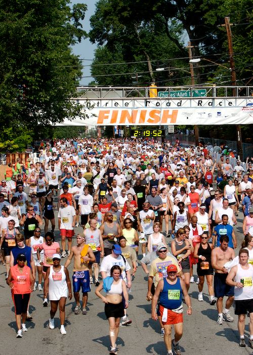 Thousands of runners crossing the Peachtree Road Race finish line