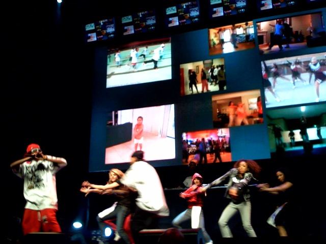 Soulja Boy on stage with a line of dancers in front of large video screens