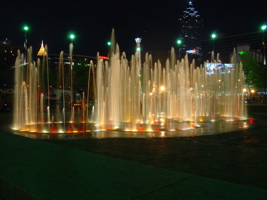 Fountain jets glowing gold at night in Centennial Olympic Park