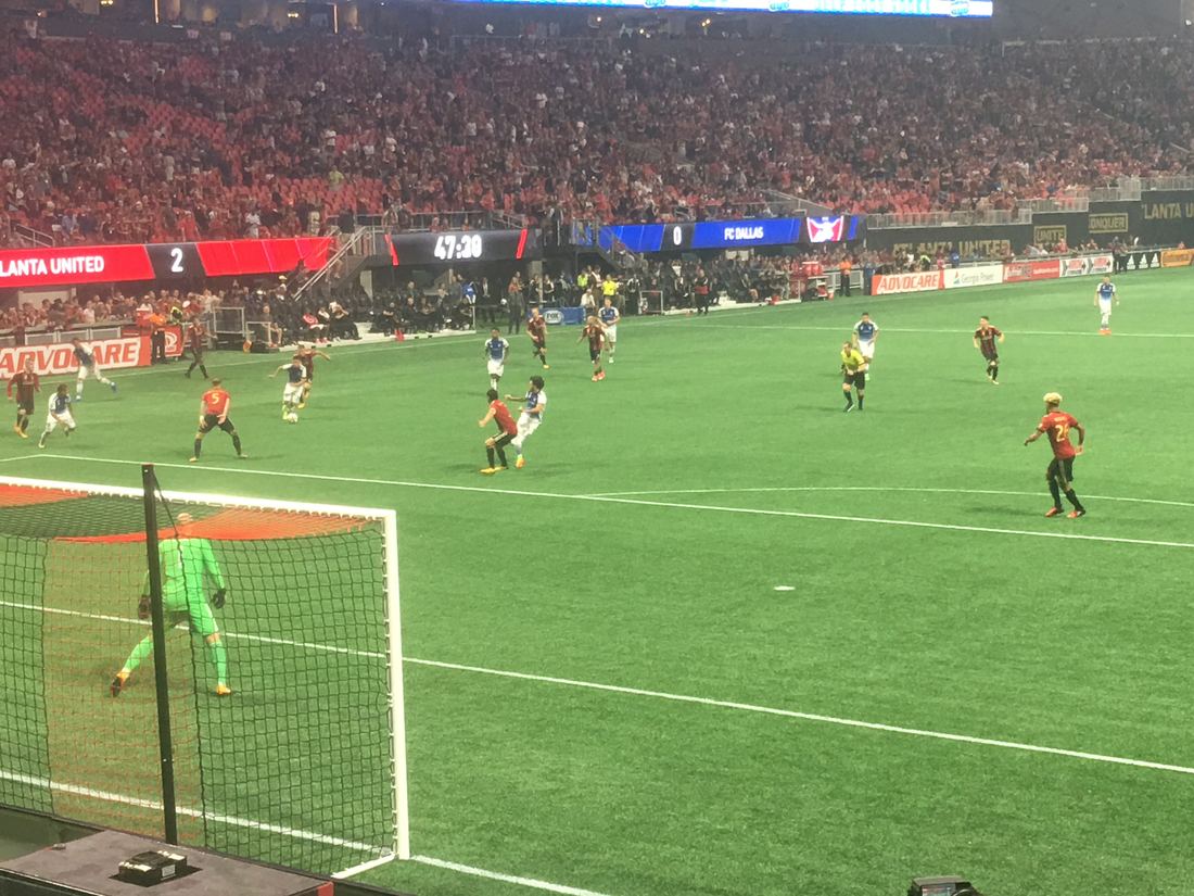 Soccer match on the pitch inside Mercedes-Benz Stadium with a packed crowd